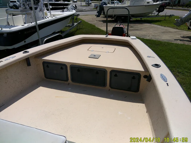 Slide: The Image of 2002 Intruder 20 Skiff boat interior with storage compartments, parked outdoors. - 7