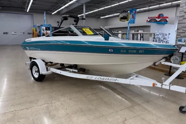 The Image of 1991 Larson All American 170 boat on trailer in showroom. - 0