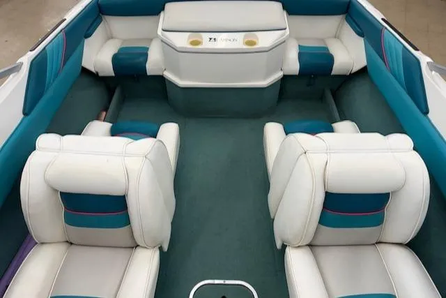 Slide: The Image of Interior of a 1991 Larson All American 170 boat with white and teal seating. - 13