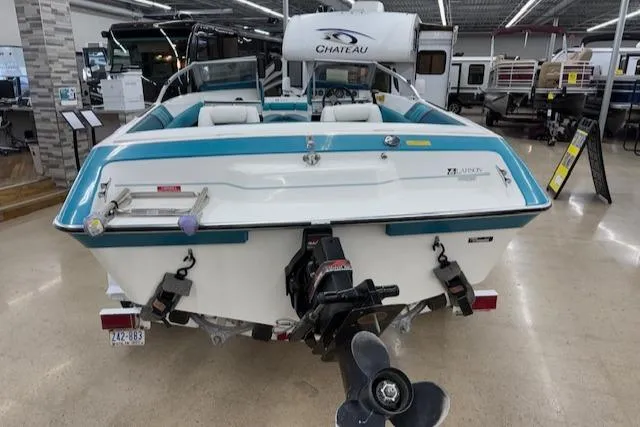 Slide: The Image of 1991 Larson All American 170 boat displayed indoors, showcasing rear view and motor. - 3