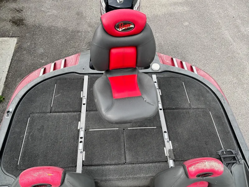 Slide: The Image of 2006 Ranger Z19 Comanche boat interior with red and black seating and carpeted deck. - 9