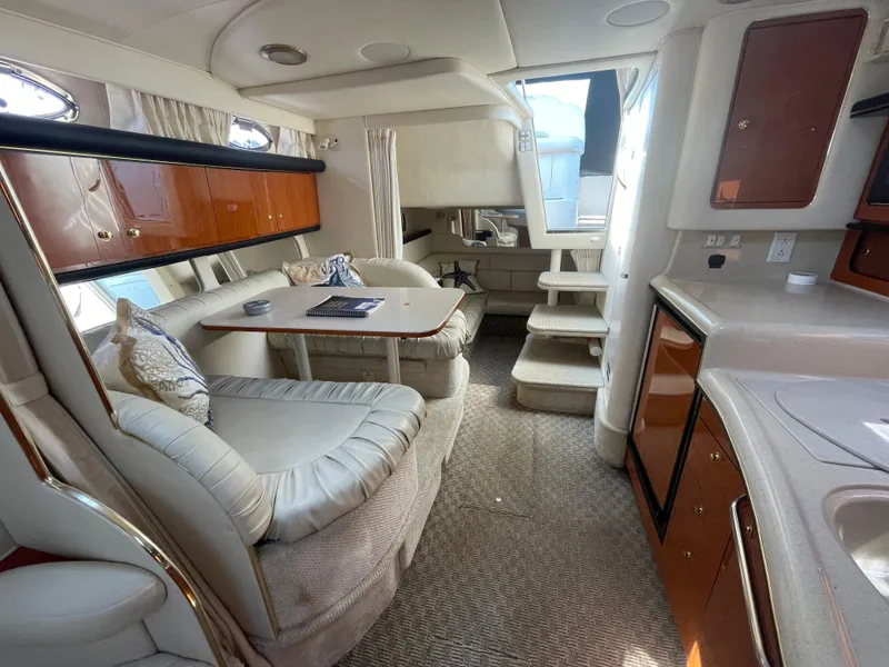 Slide: The Image of Interior of 2001 Sea Ray 340 Sundancer yacht with seating, table, and kitchenette. - 10