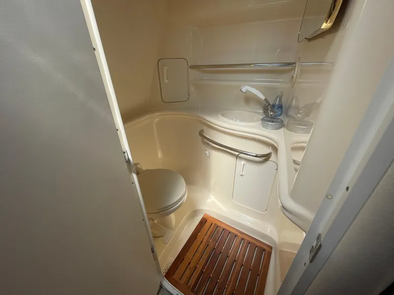 Slide: The Image of 2001 Sea Ray 340 Sundancer bathroom with toilet, sink, and wooden floor mat. - 13