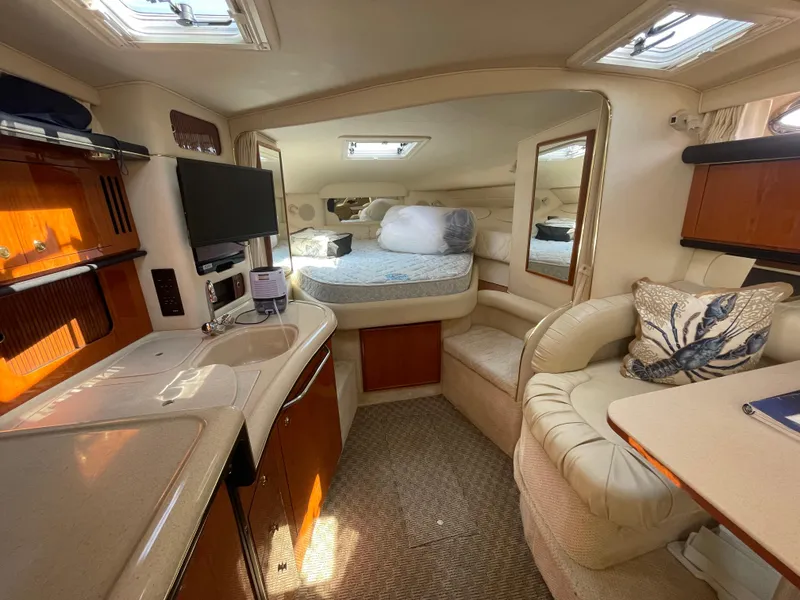 Slide: The Image of 2001 Sea Ray 340 Sundancer cabin interior with kitchenette, seating, and bed. - 14