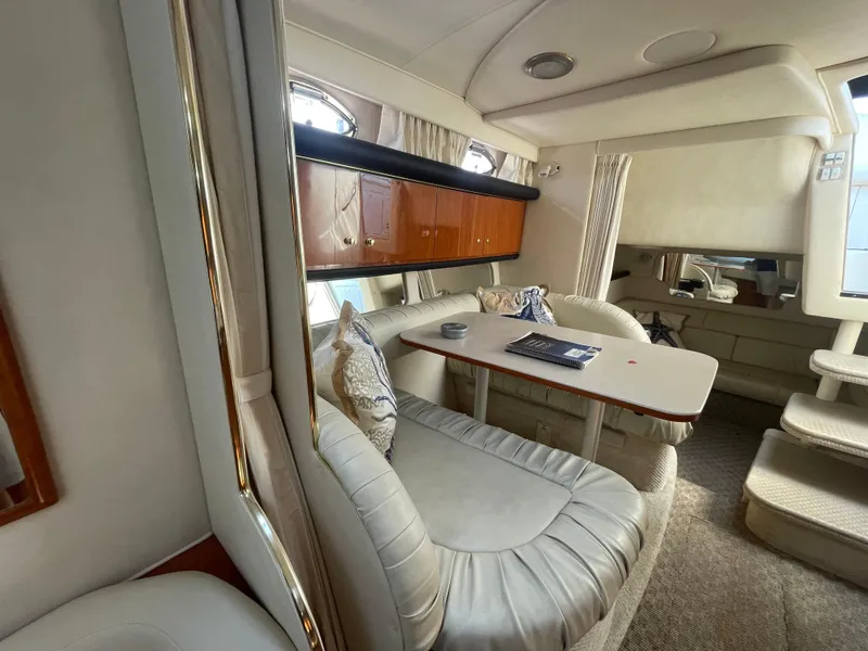 Slide: The Image of Interior of 2001 Sea Ray 340 Sundancer yacht with plush seating and wooden cabinetry. - 17