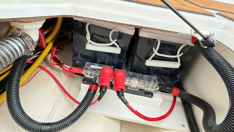 Slide: The Image of Battery compartment of 2026 Ranger Tugs R-27 with cables and connectors. - 12