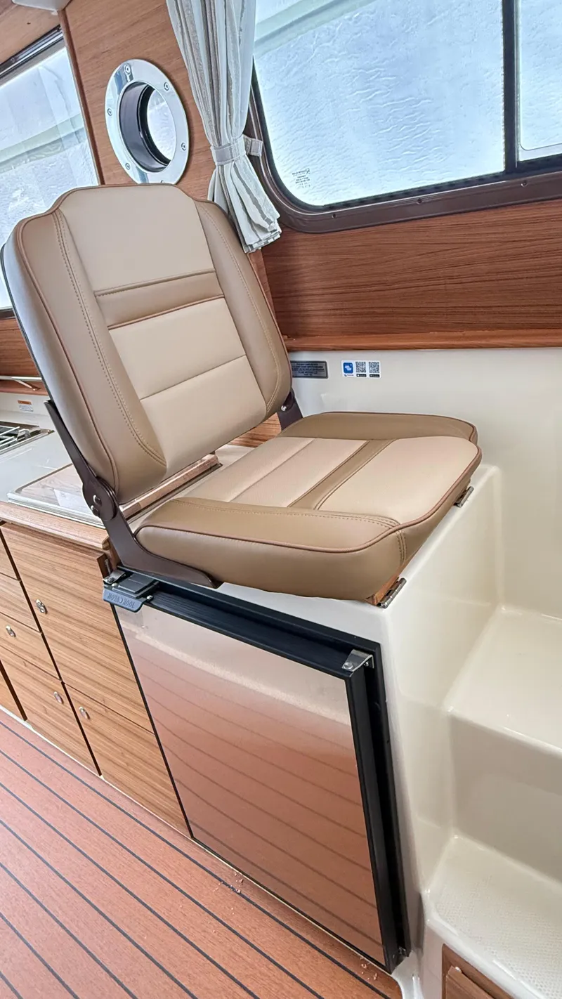 Slide: The Image of Captain's chair and kitchenette in 2026 Ranger Tugs R-27 boat interior. - 26