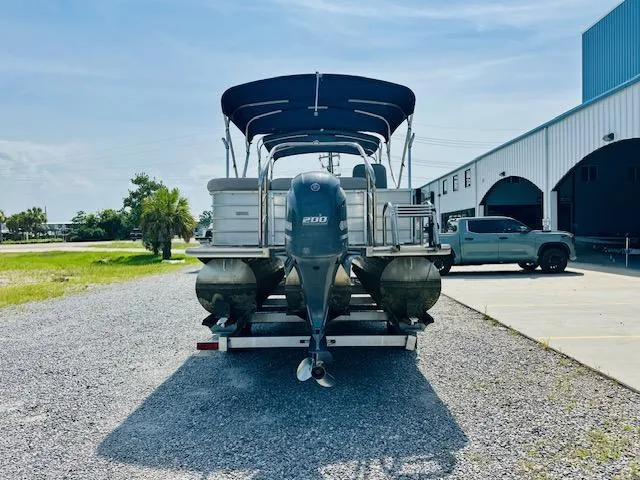 Slide: The Image of 2018 South Bay 525CPTR pontoon boat on trailer, parked near a warehouse. - 3