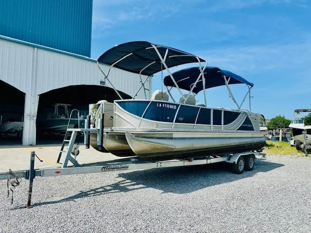 Slide: The Image of 2018 South Bay 525CPTR pontoon boat on trailer, parked outside a storage facility. - 6