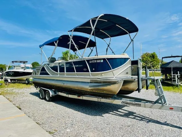 Slide: The Image of 2018 South Bay 525CPTR pontoon boat on trailer, parked outdoors under clear blue sky. - 8