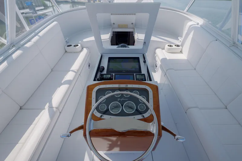 Slide: The Image of 1998 Gamefisherman Enticer boat interior with white seating and wooden steering console. - 11