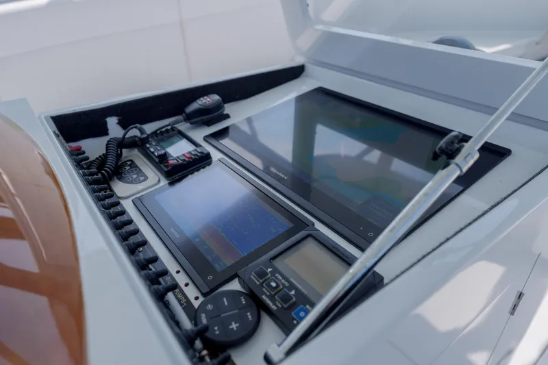 Slide: The Image of Control panel of a 1998 Gamefisherman Enticer boat with navigation screens and communication devices. - 13