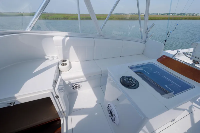 Slide: The Image of 1998 Gamefisherman Enticer boat interior with white seating and fishing equipment. - 16