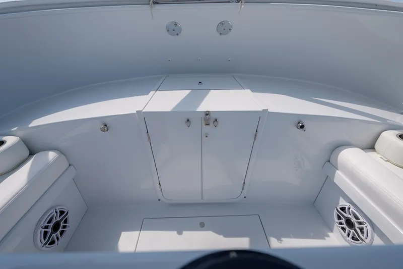 Slide: The Image of 1998 Gamefisherman Enticer boat interior with white seating and storage compartments. - 17