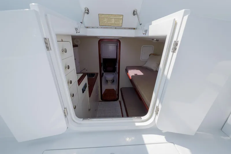 Slide: The Image of 1998 Gamefisherman Enticer cabin interior with bed, storage, and compact bathroom. - 18