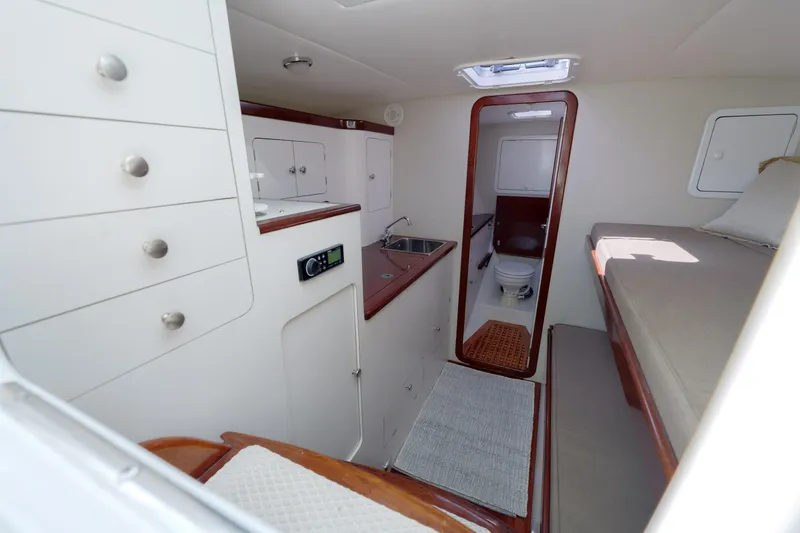 Slide: The Image of 1998 Gamefisherman Enticer cabin interior with kitchenette, bed, and bathroom. - 19