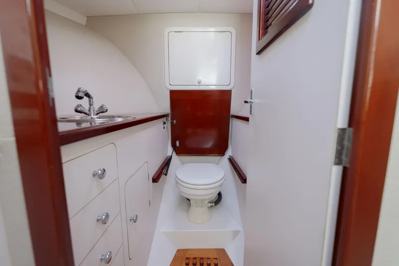 Slide: The Image of 1998 Gamefisherman Enticer boat bathroom with sink, toilet, and wooden accents. - 24
