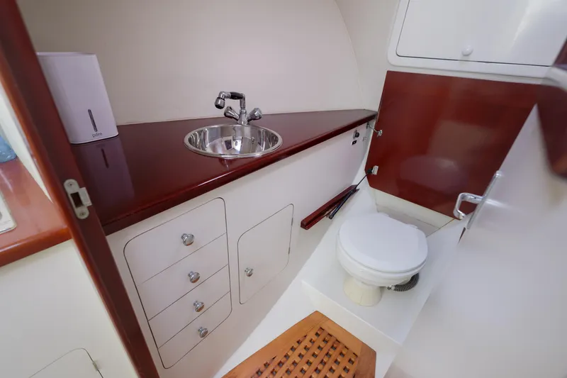 Slide: The Image of 1998 Gamefisherman Enticer boat bathroom with sink, toilet, and storage cabinets. - 25