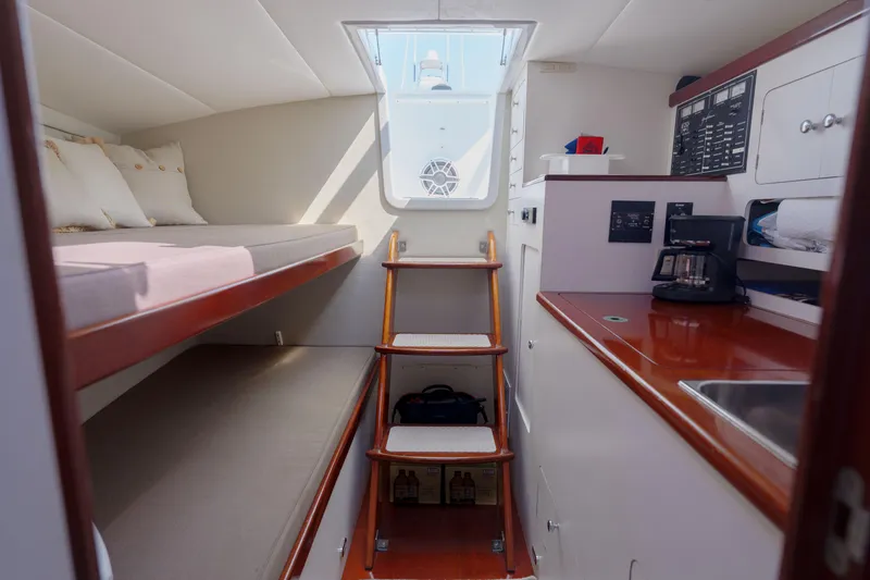 Slide: The Image of 1998 Gamefisherman Enticer cabin interior with bunk beds, kitchenette, and wooden stairs. - 26