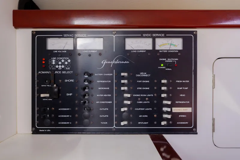 Slide: The Image of Electrical control panel on a 1998 Gamefisherman Enticer boat, featuring various switches and indicators. - 27