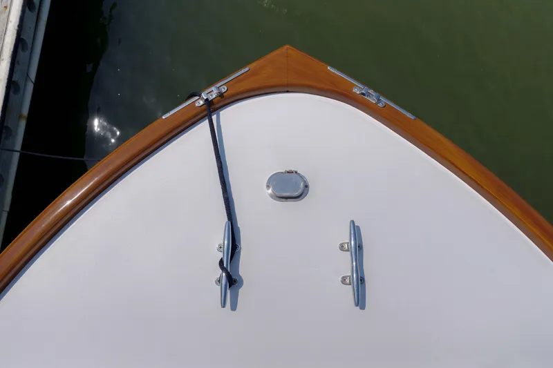 Slide: The Image of Bow of 1998 Gamefisherman Enticer boat with cleats and rope, docked on calm water. - 31