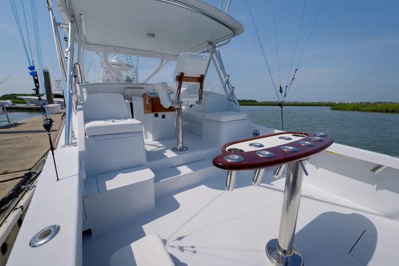 Slide: The Image of 1998 Gamefisherman Enticer boat with fishing rods, docked by a serene waterway. - 39