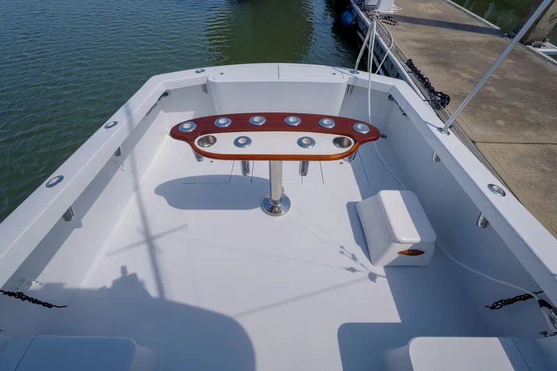 Slide: The Image of 1998 Gamefisherman Enticer boat deck with rod holders and seating, docked at marina. - 40