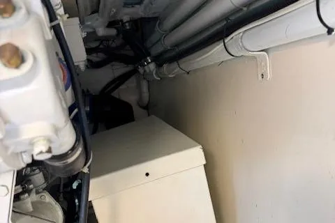 Slide: The Image of Engine room of 1998 Gamefisherman 34 Express, showing pipes and mechanical components. - 50