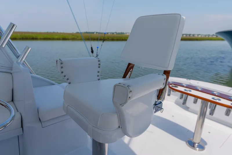 Slide: The Image of White captain's chair on 1998 Gamefisherman Enticer boat, with fishing rod holders in background. - 6