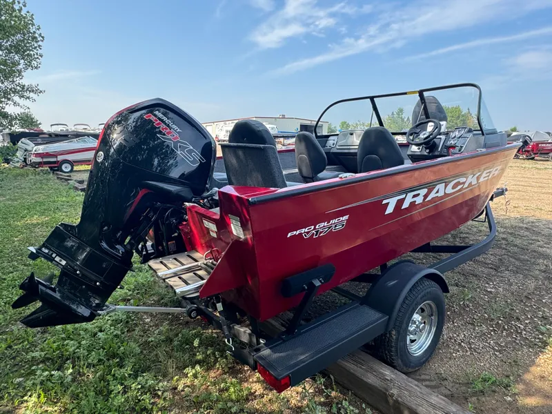 Slide: The Image of 2025 Tracker Pro Guide V-175 Combo boat with Mercury engine, parked outdoors. - 3