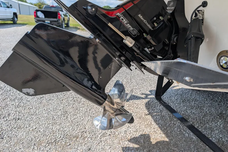 Slide: The Image of 2025 Sea Ray SLX 260 Surf boat engine and propeller detail on gravel surface. - 6