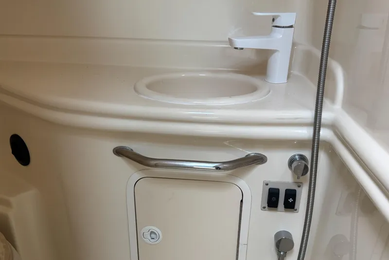Slide: The Image of 2003 Sea Ray 320 Sundancer bathroom sink with faucet and control panel. - 13