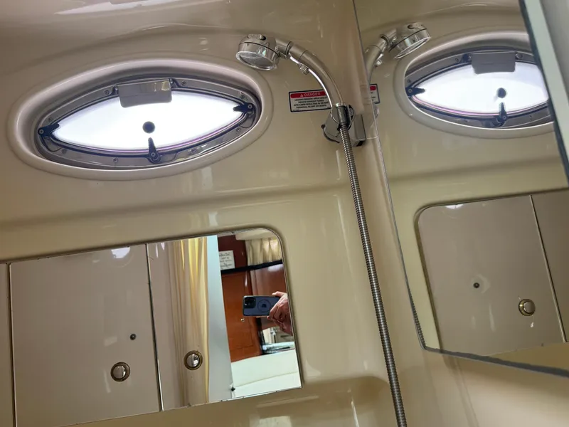 Slide: The Image of Interior of 2003 Sea Ray 320 Sundancer bathroom with showerhead and porthole window. - 14