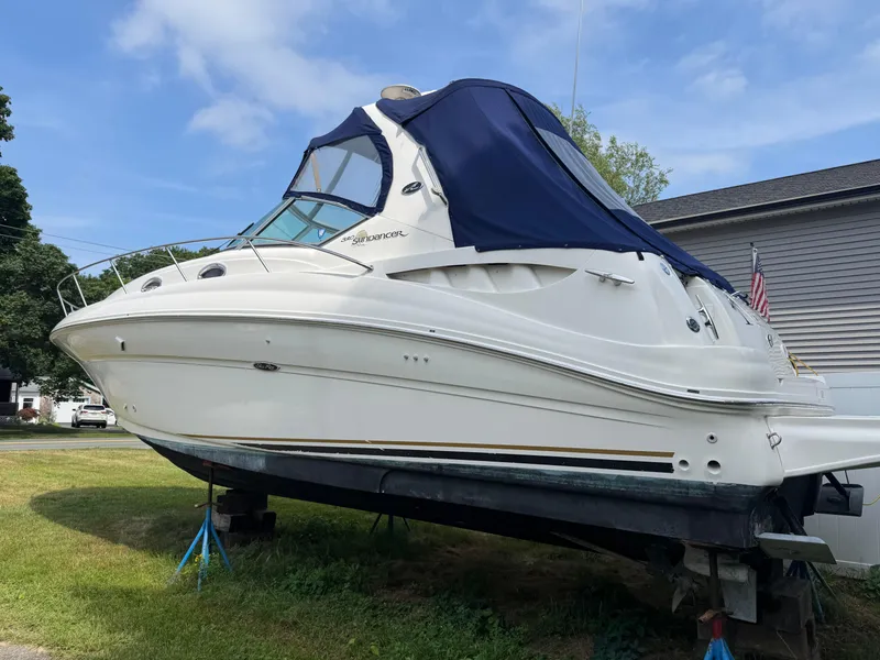 Slide: The Image of 2003 Sea Ray 320 Sundancer boat with blue canopy on land, side view. - 18