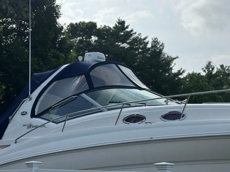 Slide: The Image of 2003 Sea Ray 320 Sundancer boat with blue canopy, docked near trees. - 20