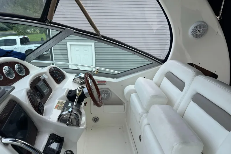 Slide: The Image of Interior of 2003 Sea Ray 320 Sundancer boat with white seating and control panel. - 25