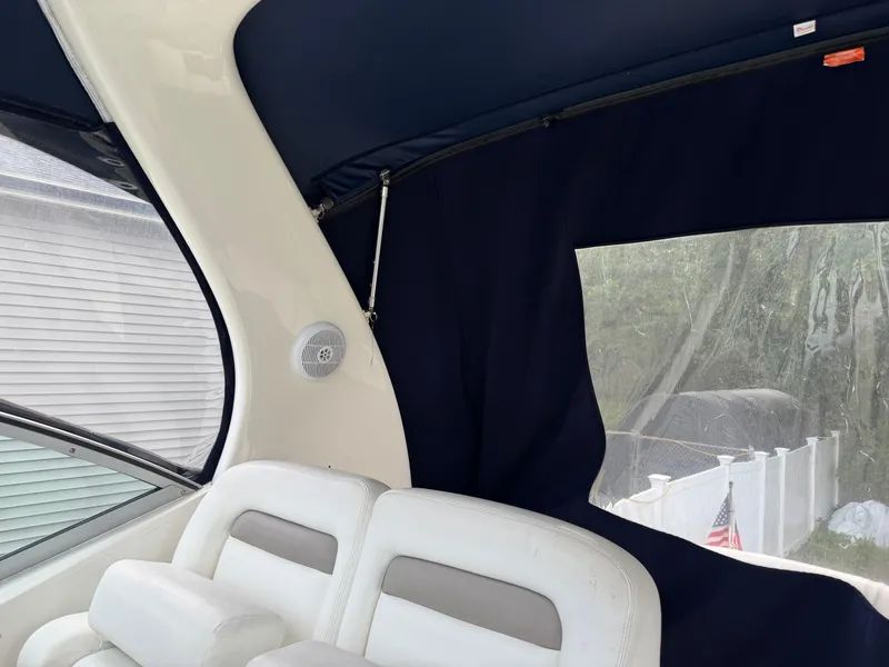 Slide: The Image of Interior of a 2003 Sea Ray 320 Sundancer with white seating and navy blue canopy. - 26