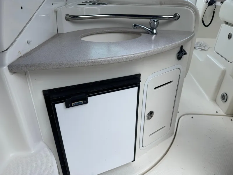 Slide: The Image of 2003 Sea Ray 320 Sundancer boat kitchenette with sink and mini fridge. - 27