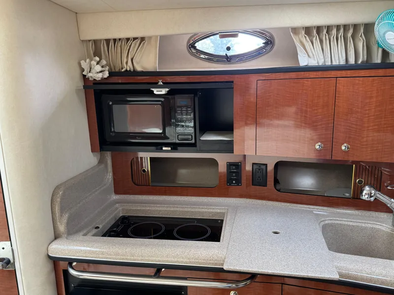 Slide: The Image of 2003 Sea Ray 320 Sundancer galley with microwave, stove, and sink. - 9