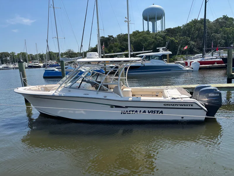 Slide: The Image of 2011 Grady-White Freedom 275 boat docked in a marina with water tower background. - 0