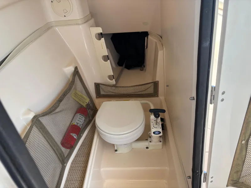 Slide: The Image of Interior of 2011 Grady-White Freedom 275 boat featuring a compact marine toilet. - 11