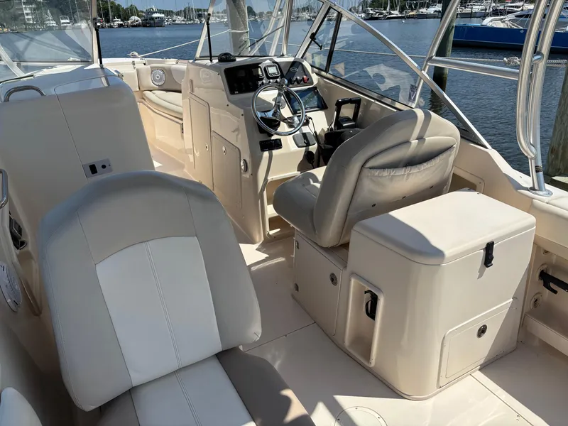 Slide: The Image of Interior of a 2011 Grady-White Freedom 275 boat, featuring helm and seating area. - 14