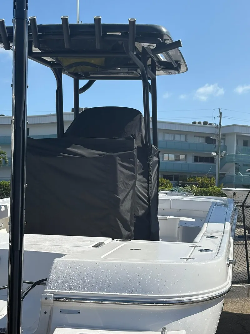 Slide: The Image of 2023 Caymas 28 HB boat with T-top and covered console, docked under clear blue sky. - 11