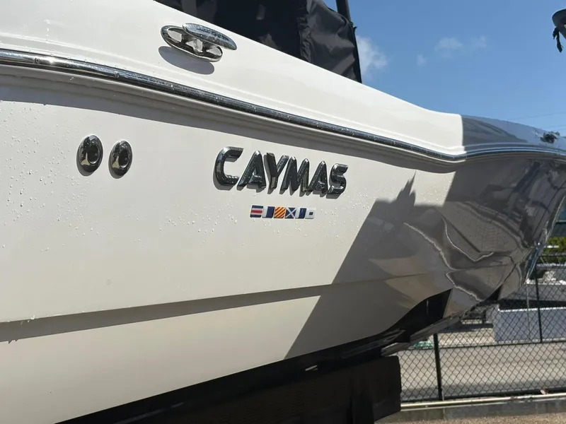 Slide: The Image of 2023 Caymas 28 HB boat, close-up of logo and sleek white hull. - 12