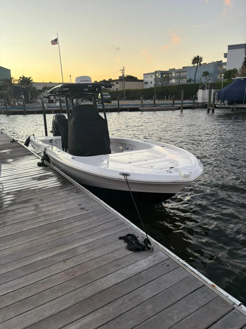 Slide: The Image of 2023 Caymas 28 HB boat docked at sunset, calm waters, and marina backdrop. - 2