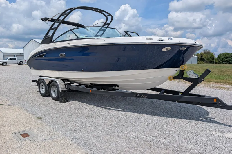 Slide: The Image of 2025 Sea Ray SDX 250 boat on trailer, parked outdoors under cloudy sky. - 1