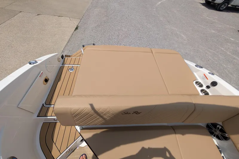 Slide: The Image of 2025 Sea Ray SDX 250 boat with tan seating and deck, parked on pavement. - 21