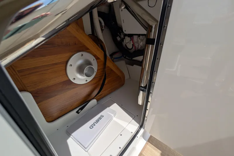 Slide: The Image of 2025 Sea Ray SDX 250 interior storage compartment with wooden flooring and equipment. - 27