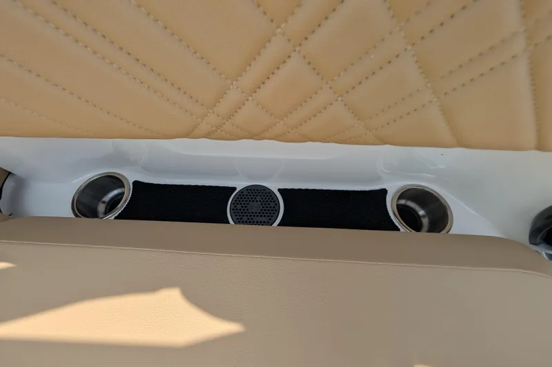 Slide: The Image of 2025 Sea Ray SDX 250 boat interior with beige quilted upholstery and cup holders. - 32