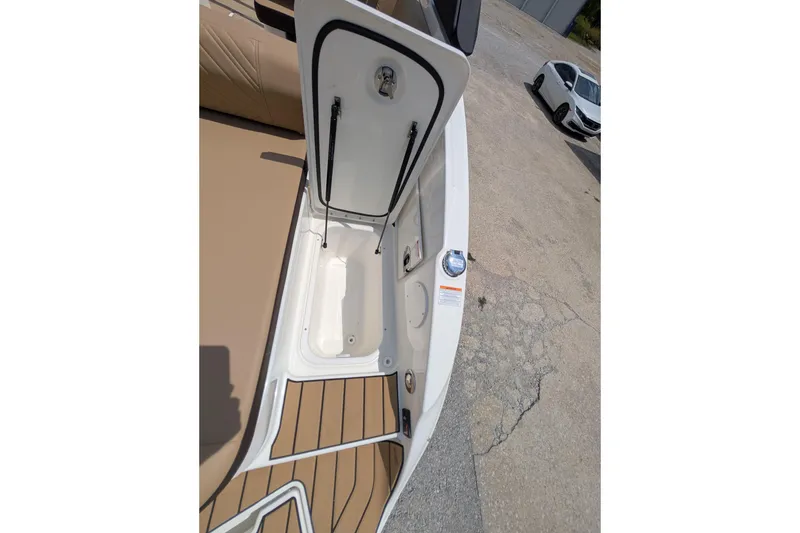 Slide: The Image of 2025 Sea Ray SDX 250 boat with open storage compartment and tan deck. - 34